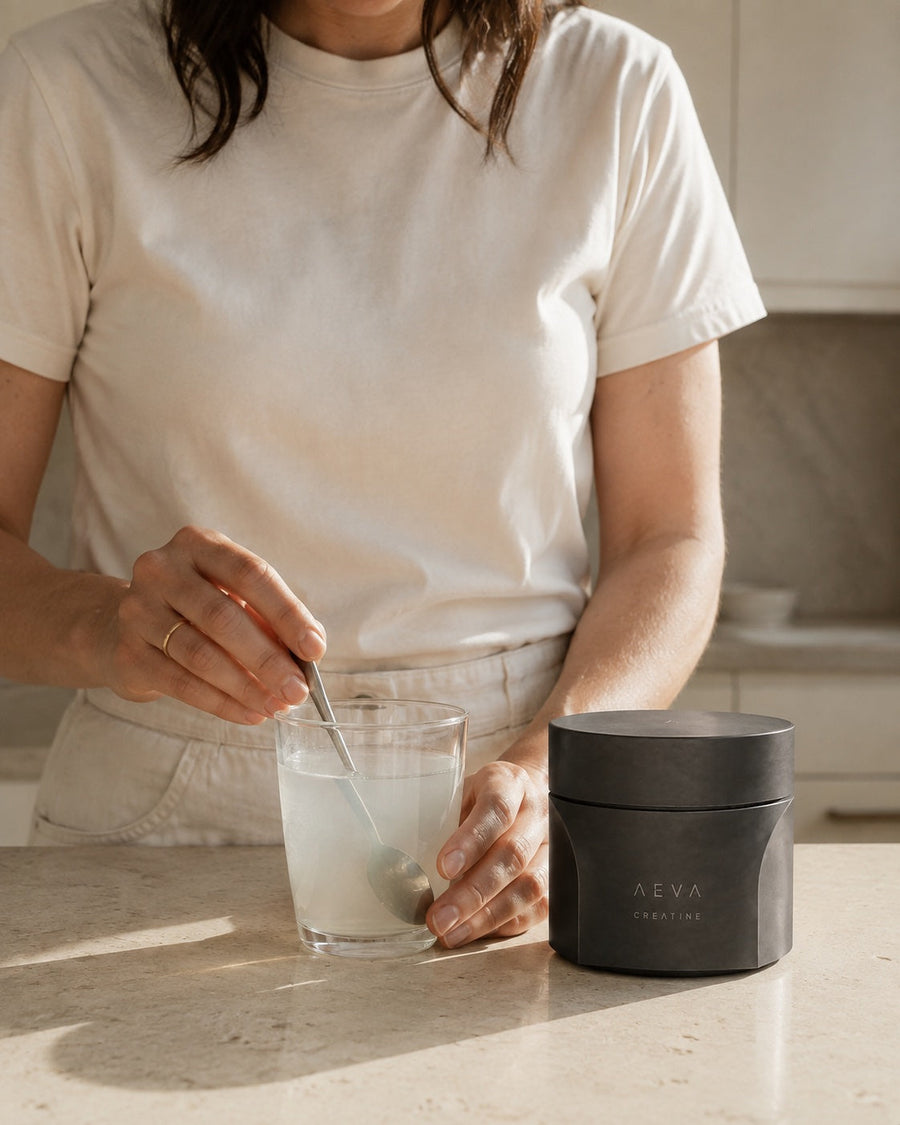 Preparing a glass of creatine beside the AEVA jar